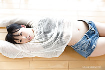 Lying on her back arms raised wearing shorts